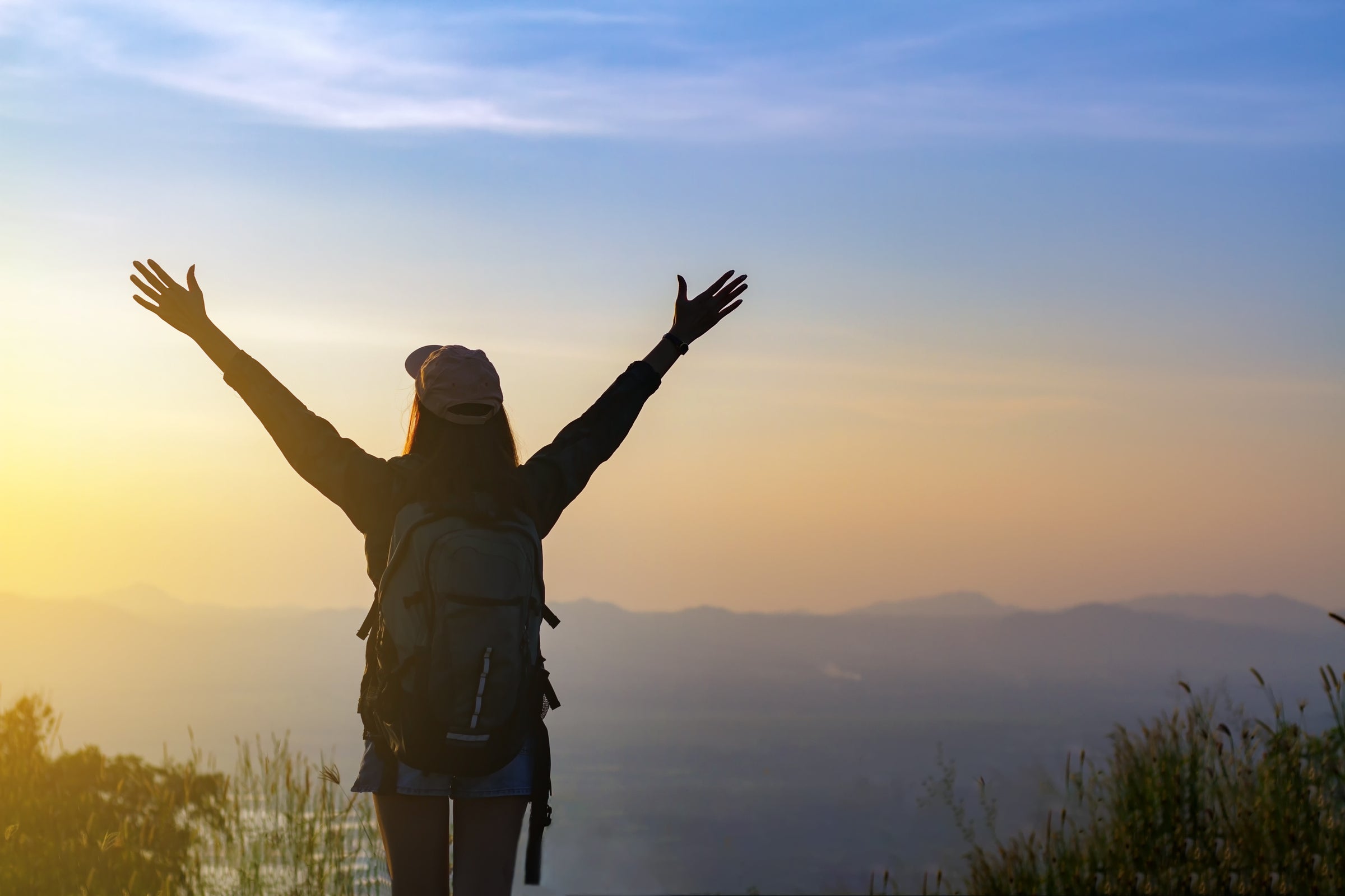 2400-woman-has-raised-arms-on-mountain-peak.jpg