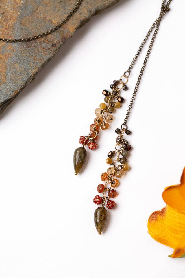 Close-up view of the Fireside Collection Lariat Necklace, featuring warm-toned gemstones and a unique mixed metal chain.