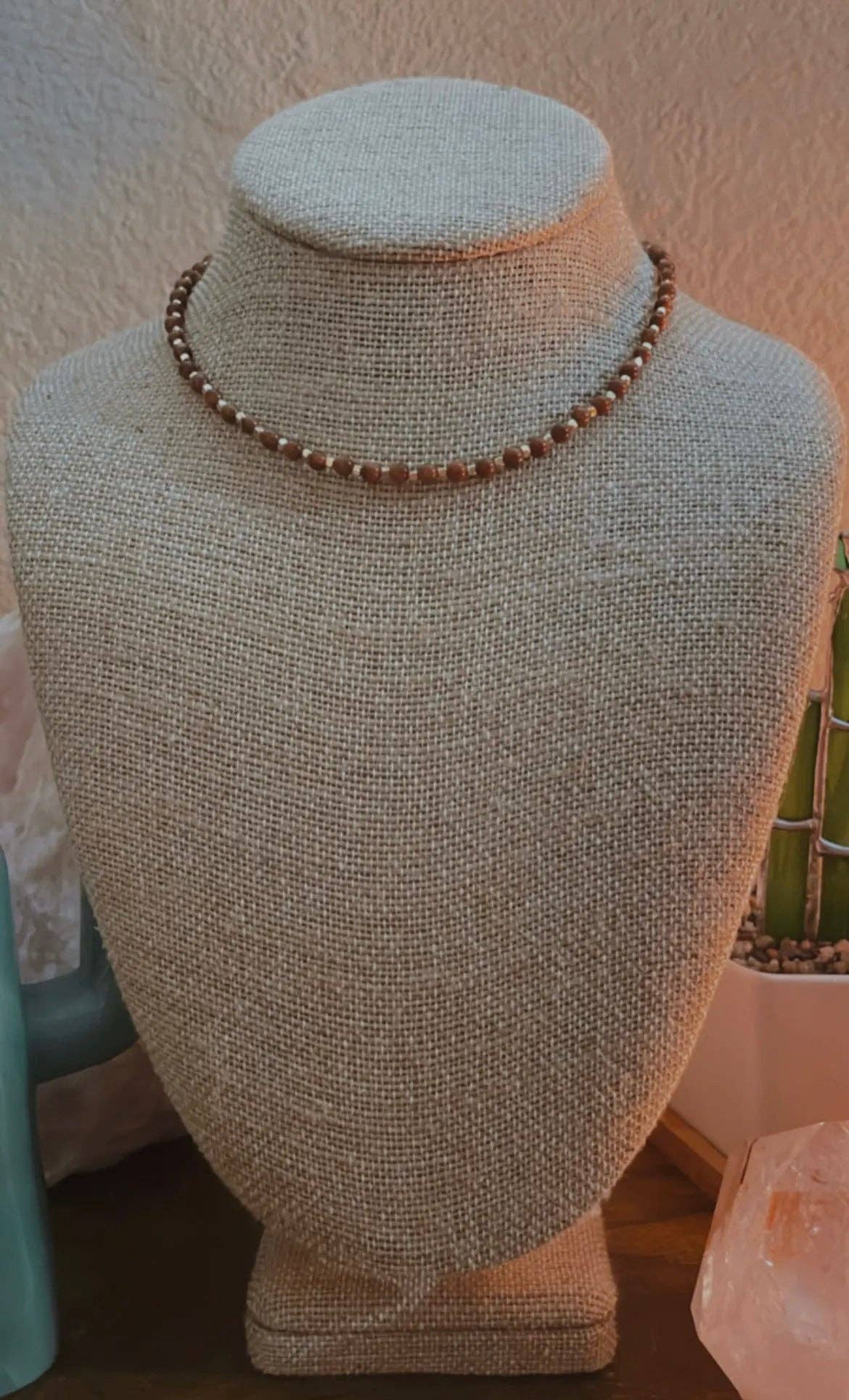 Goldstone Choker Necklace displayed on a beige mannequin bust, highlighting the shimmering goldstone beads and adjustable length.