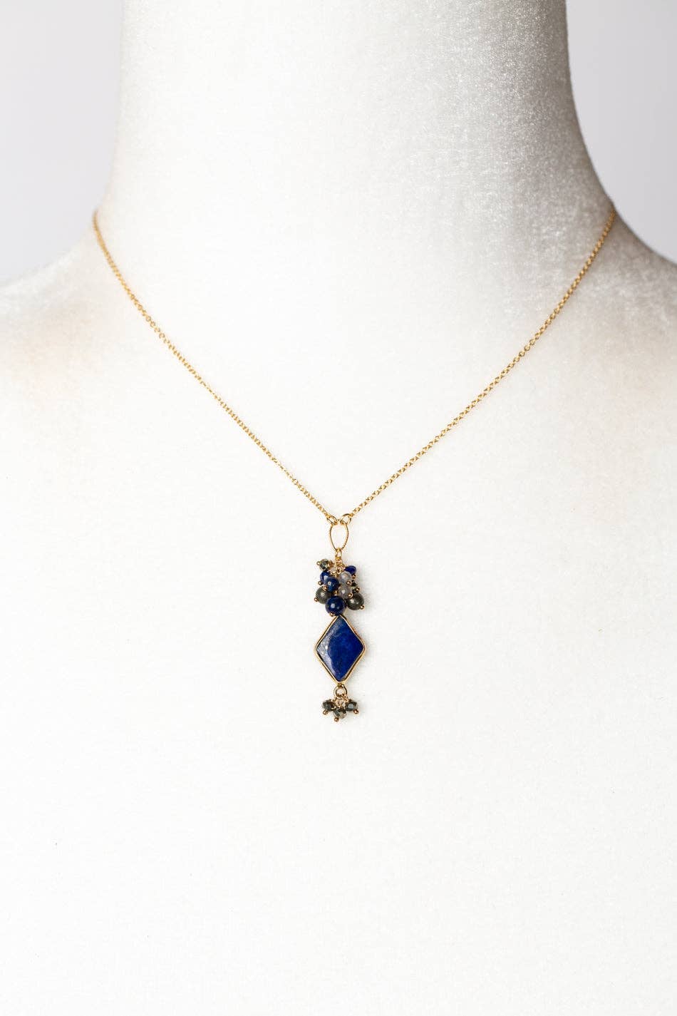 Handcrafted Cluster Pendant Necklace with a bold lapis focal, shown on a white mannequin bust to display its elegant and adjustable design.