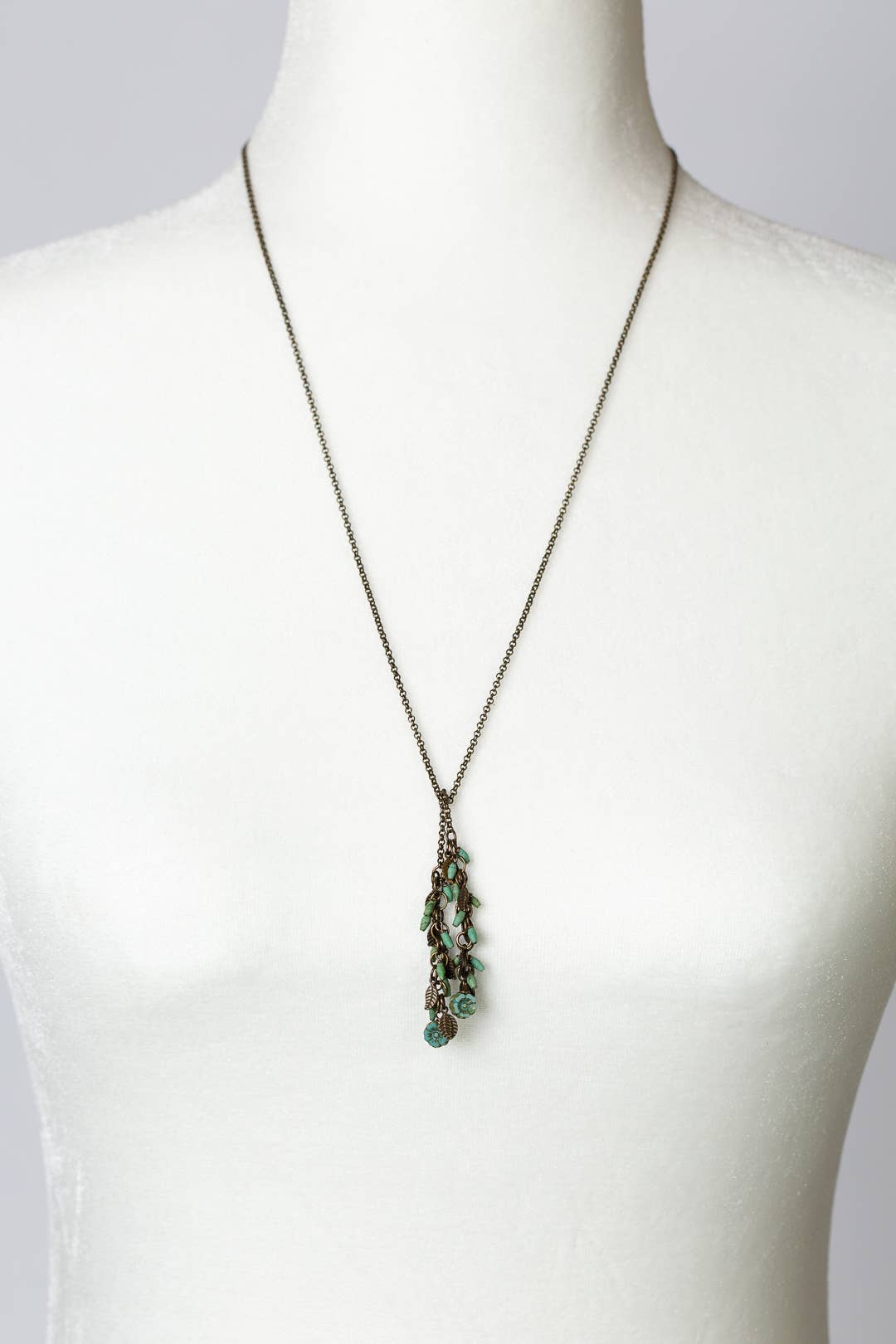 The Turquoise and Czech Glass Lariat Necklace displayed on a white mannequin, showcasing its 26.5-inch length and elegant design.