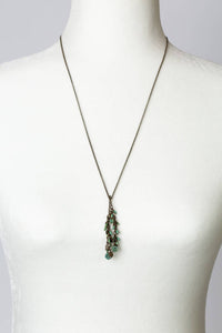 The Turquoise and Czech Glass Lariat Necklace displayed on a white mannequin, showcasing its 26.5-inch length and elegant design.