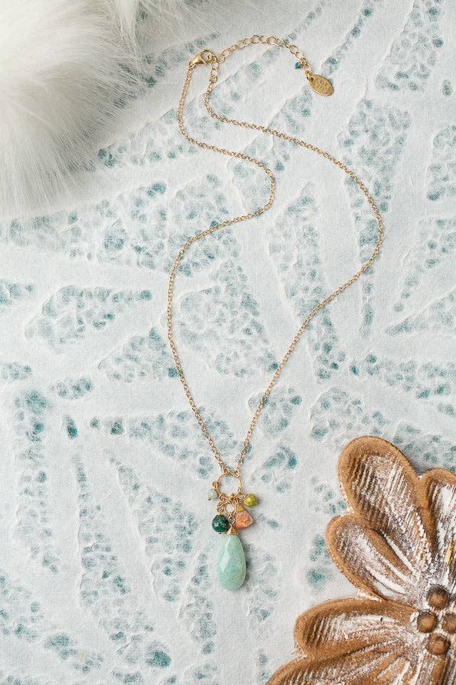 A Chrysocolla, Olive Jade & Amazonite Necklace featuring a soft colorway with a beautiful amazonite focal, displayed on a textured background.