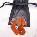 Creative Fire-themed crystal medicine pouch with Carnelian stones in a black organdy pouch.