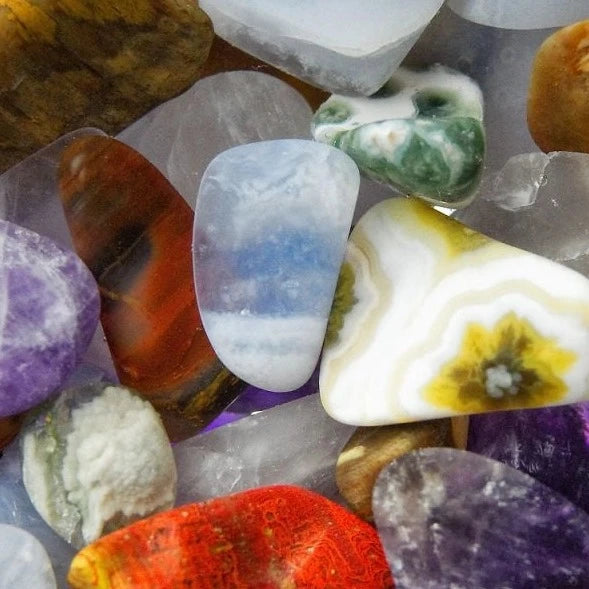 close up view of gemstones: Rose Quartz, Chalcedony, Petrified Wood, and Ocean Jasper