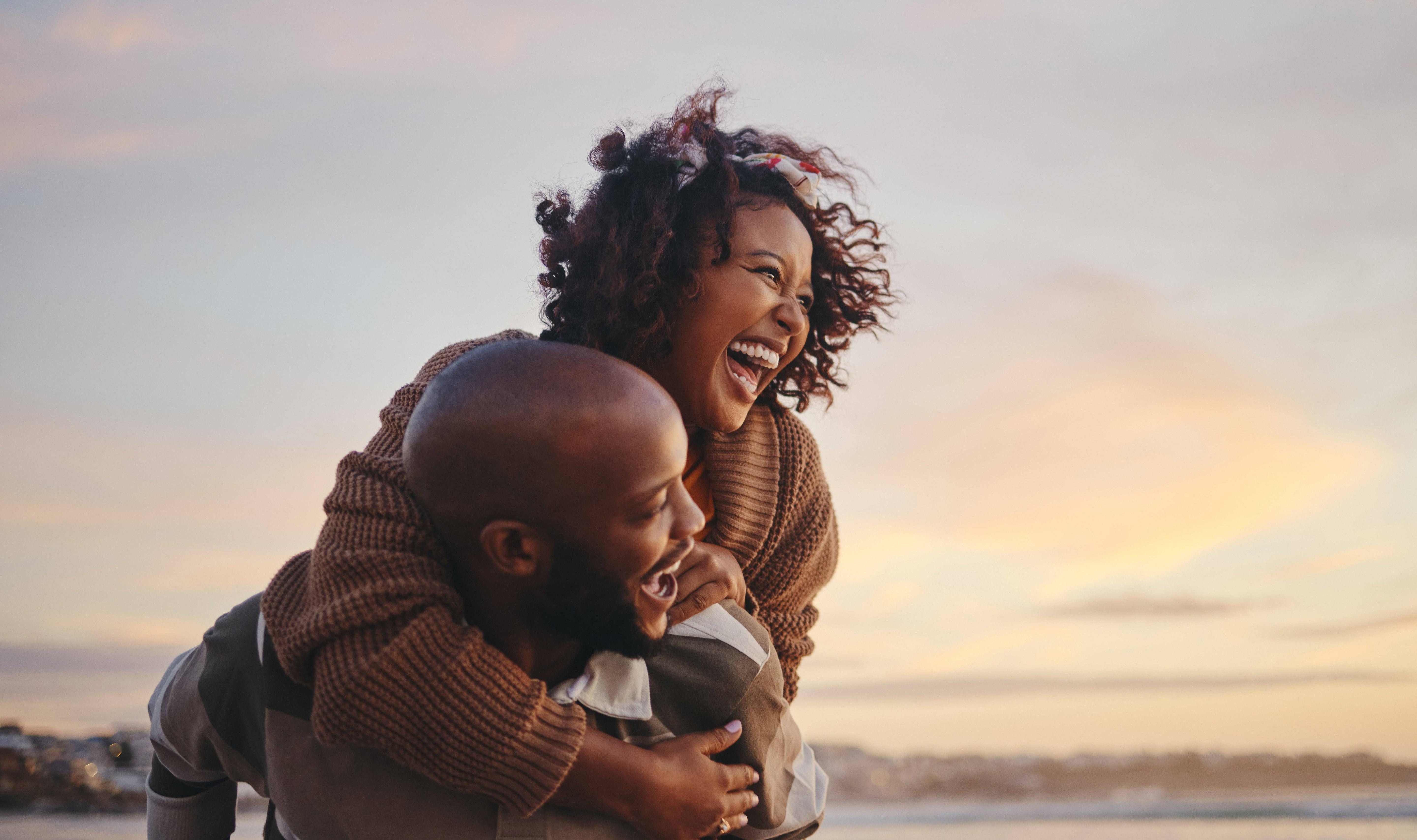 Image of a happy couple laughing on the beach