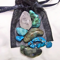 Gemini-themed crystal medicine pouch with Turquoise, Emerald, and Clear Quartz in a colorful organdy pouch.