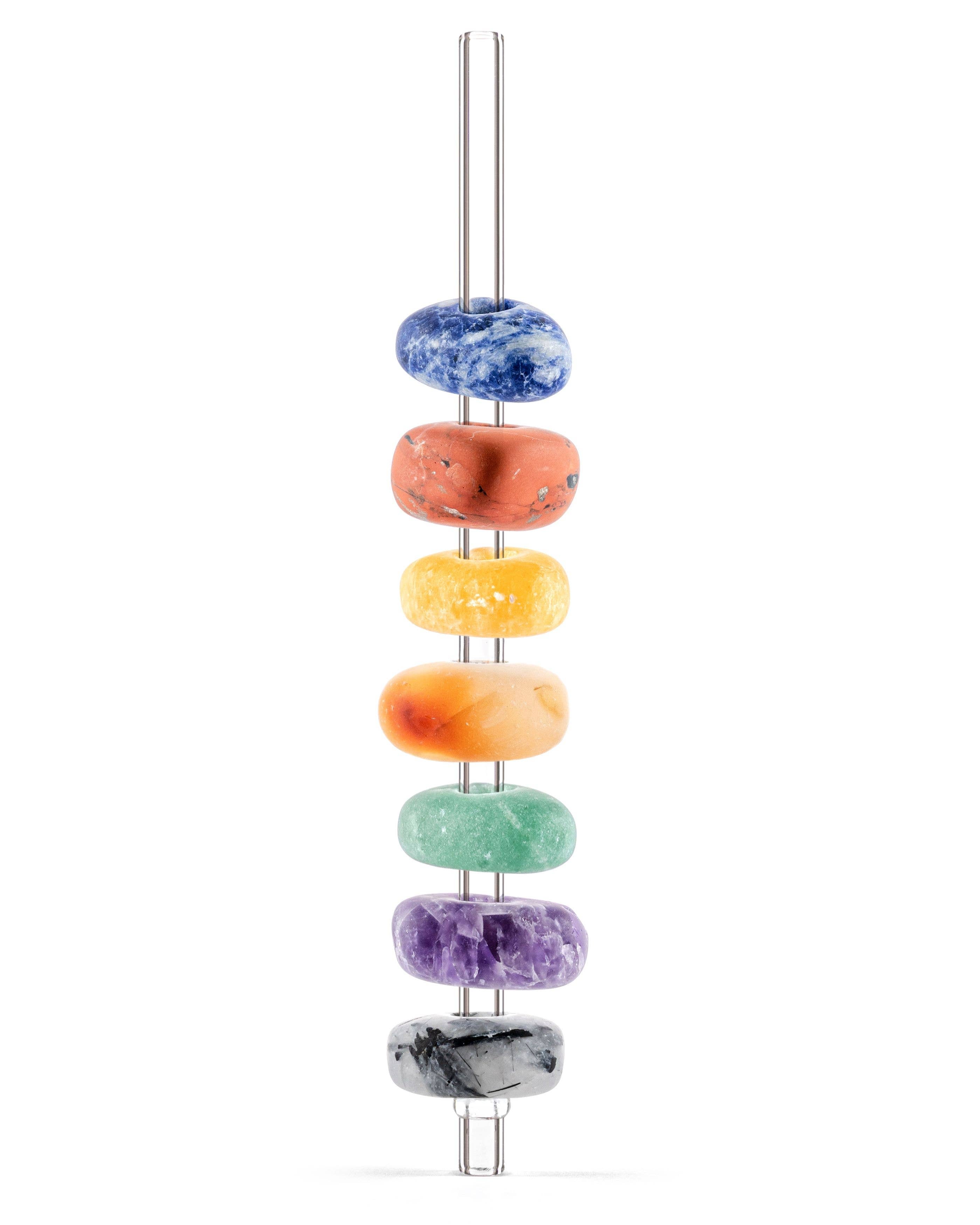 Colorful gemstones stacked in a row on a single straw.