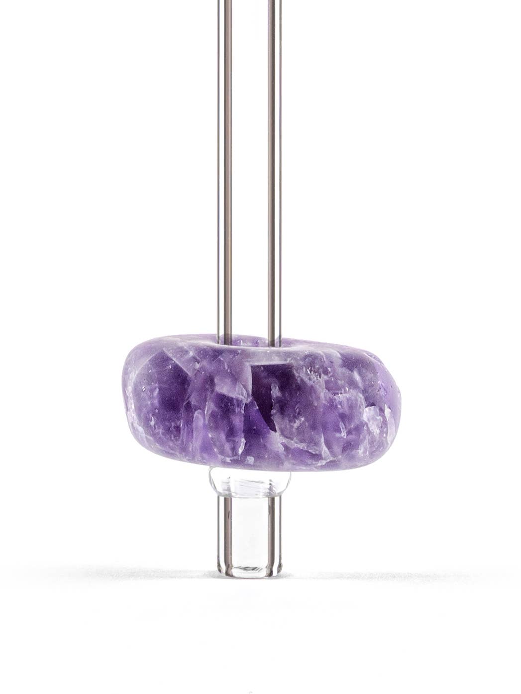 Close-up view of glass straws with an amethyst gemstone attached, showcasing the vibrant colors and unique textures of the stone.