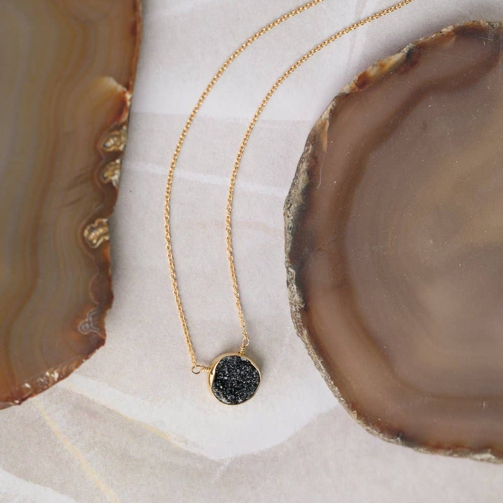 simple gold necklace with a single black druzy stone