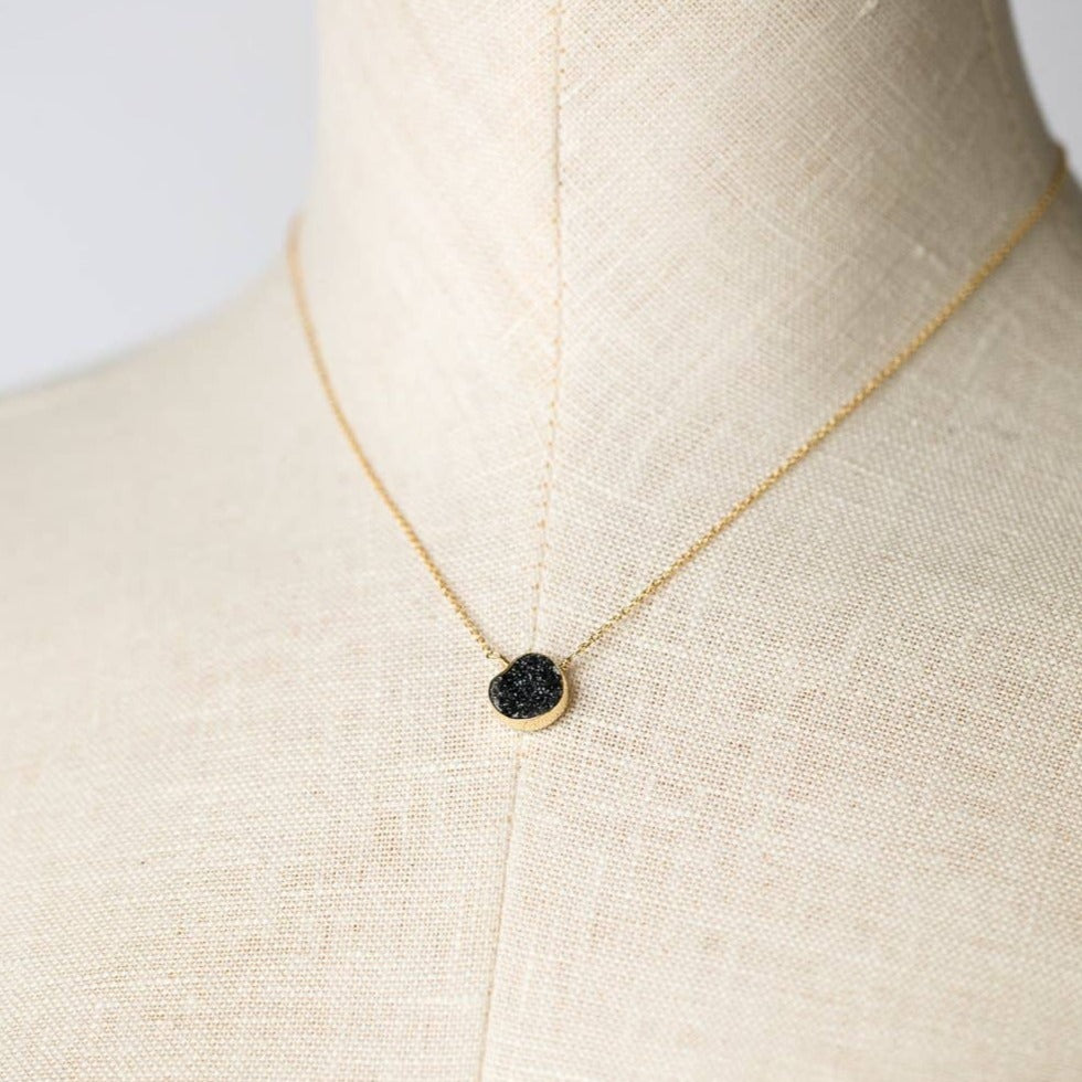 simple gold necklace with a single black druzy stone