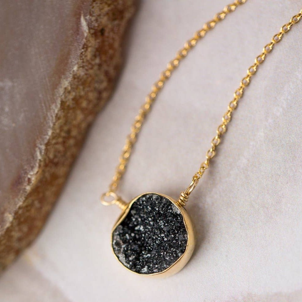 simple gold necklace with a single black druzy stone