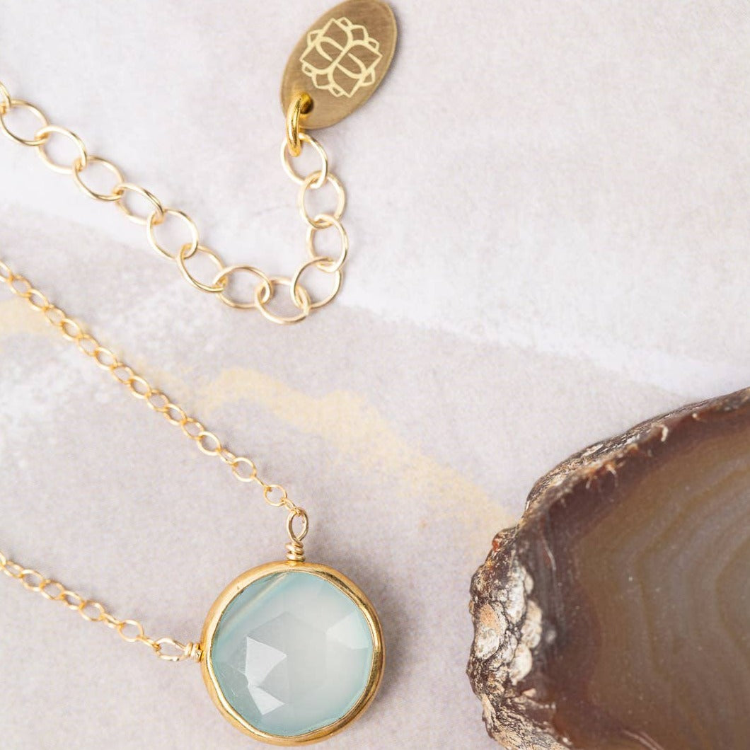 gold necklace with a single chalcedony stone