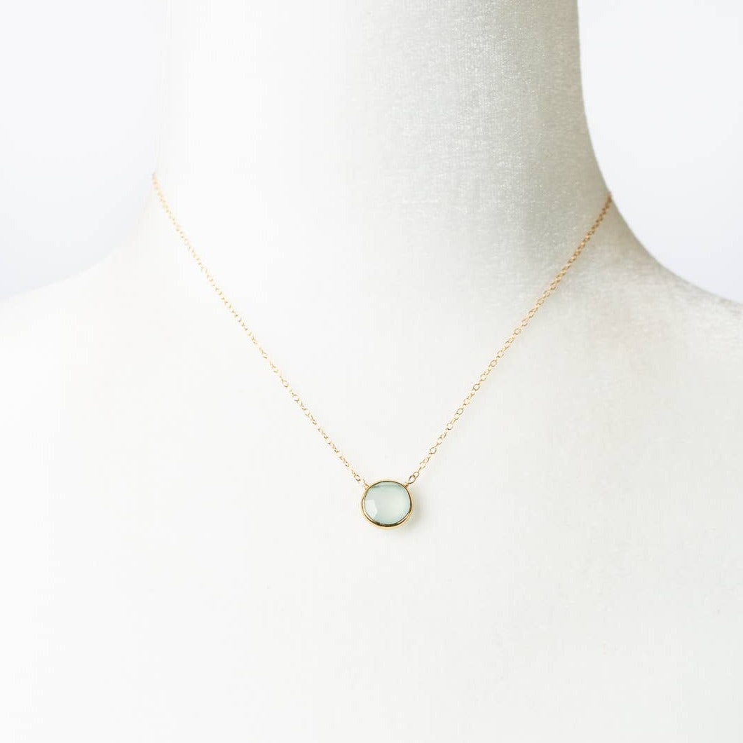 simple gold necklace with a single chalcedony stone