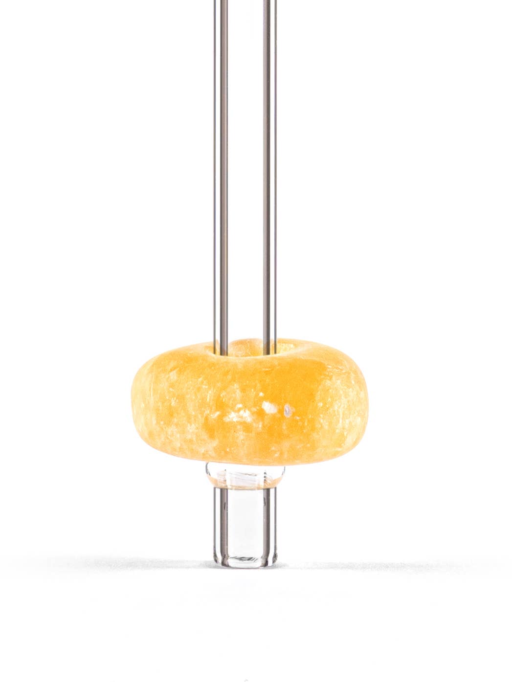 Close-up view of a glass straw with a citrine gemstone attached, showcasing the vibrant colors and unique textures of the stone.