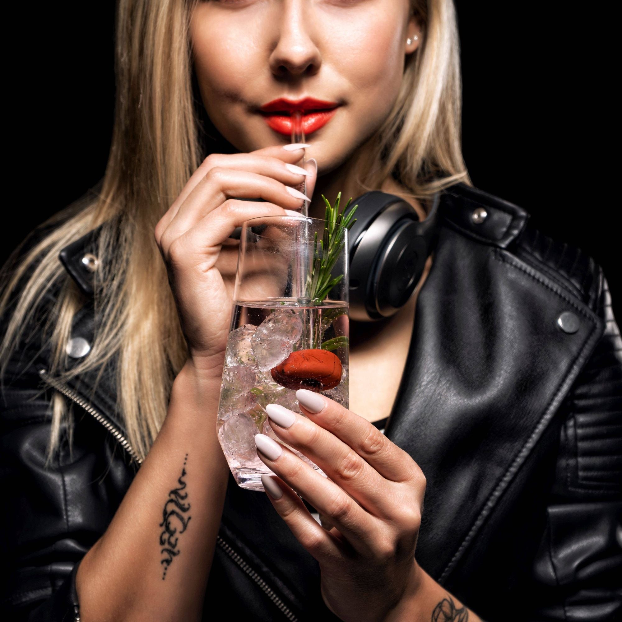 Model drinking from a glass straw with a gemstone attached, demonstrating the stylish and functional use of the straw.