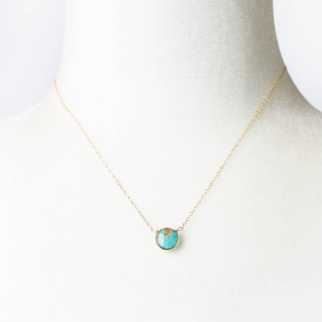 simple gold necklace with a single turquoise stone