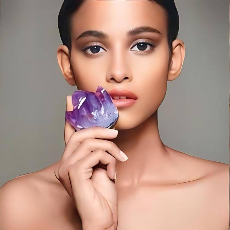 woman holding large amethyst gemstone beside her lip