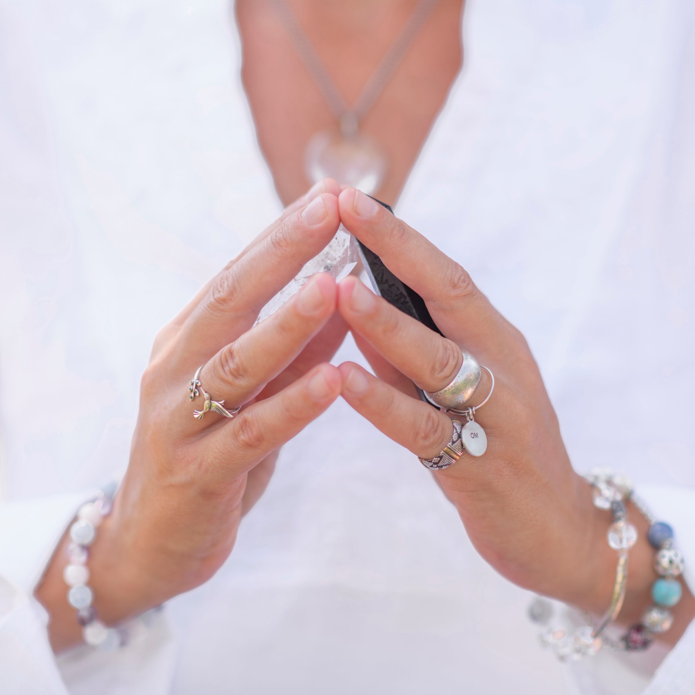 woman holding crystals in a prayer position